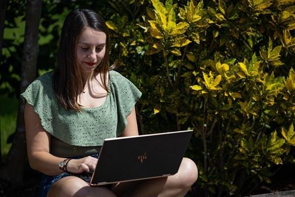 A student working on her computer outside